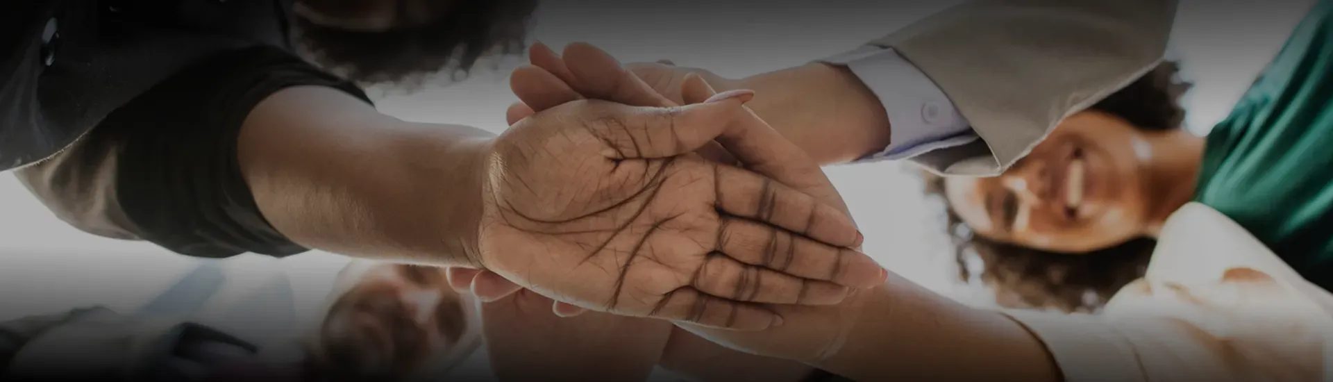 Team members joining hands together in partnership