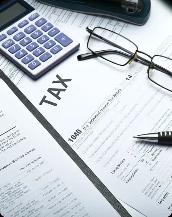 IRS tax forms 1040 with calculator and pen on desk
